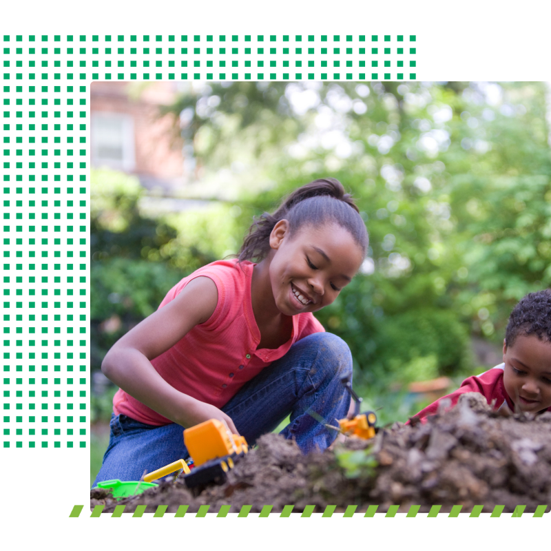 Young girl smiling and playing with toy tractors